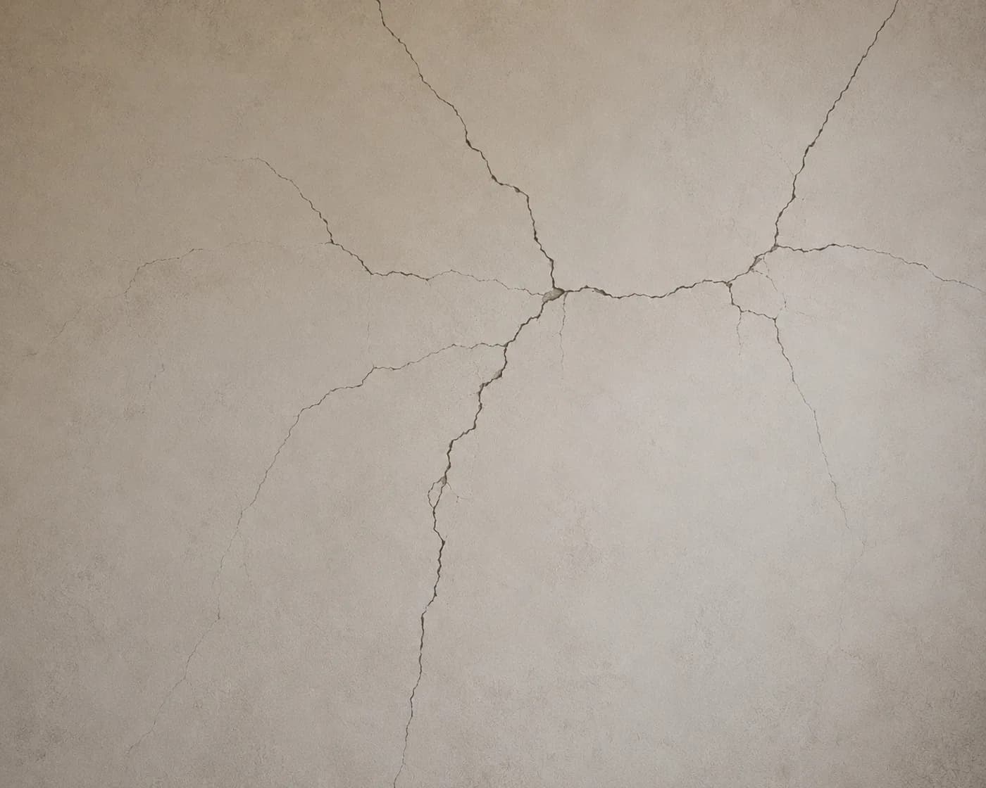 A living room wall cracked above the door frame with plaster broken away