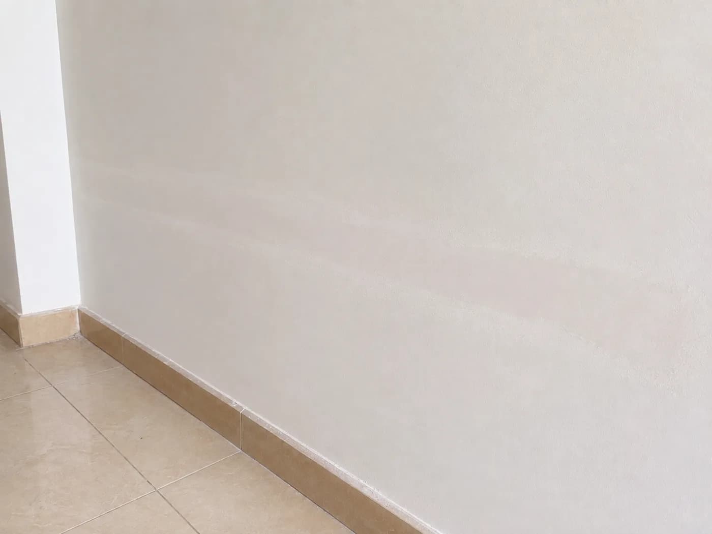 A wall filled and sanded flat, with the repaired band still showing before priming